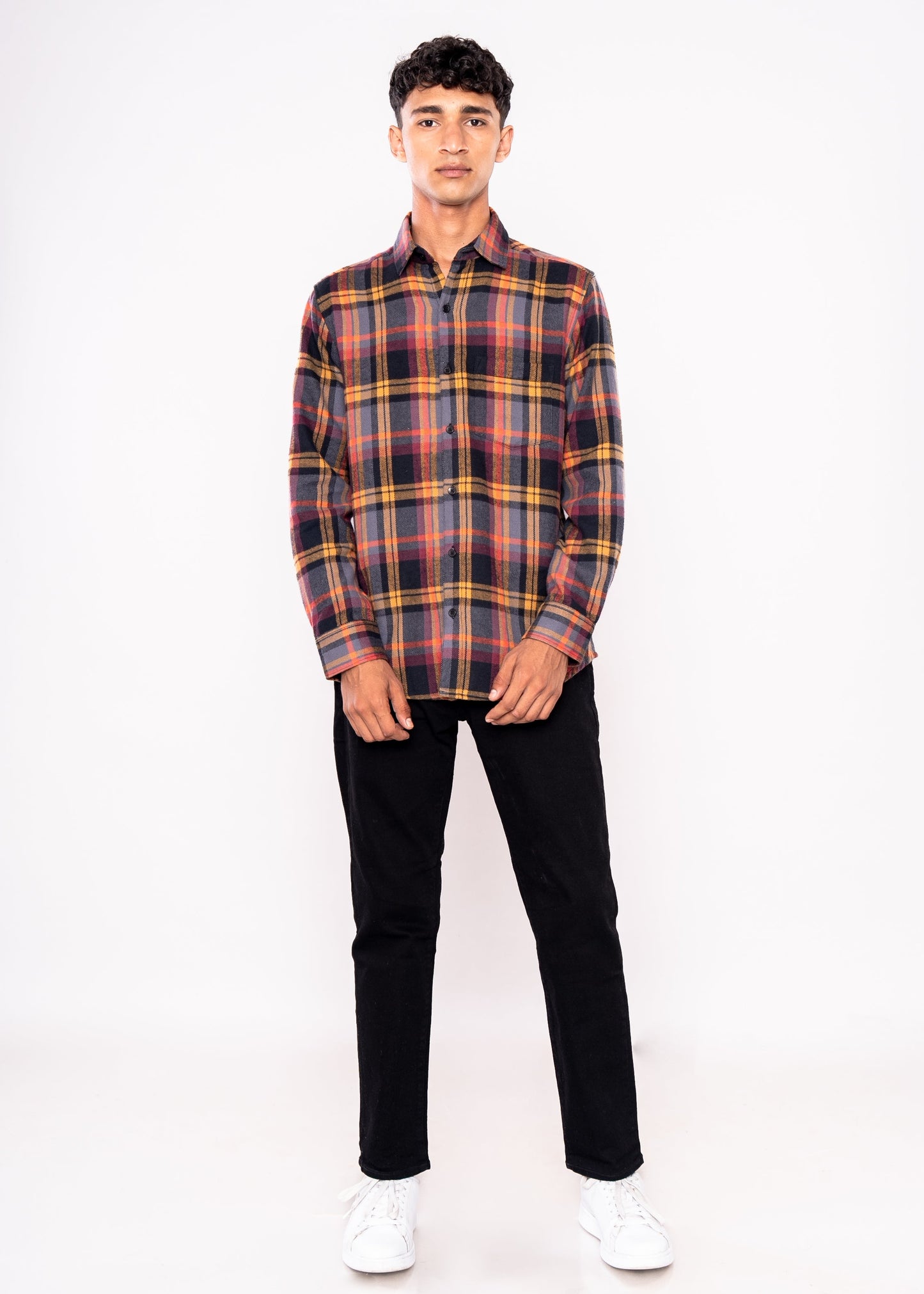 Person wearing a plaid shirt and black pants on a white background