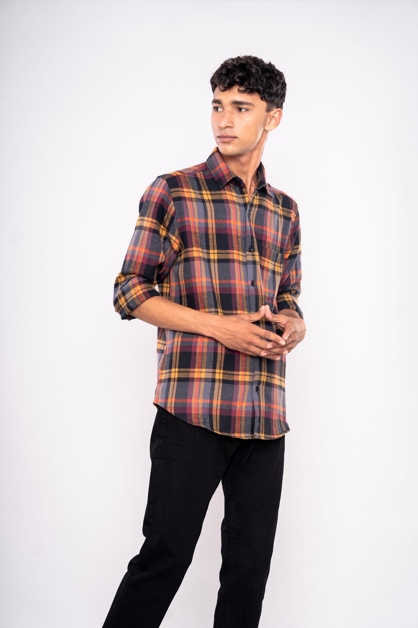 Man wearing a plaid shirt and black pants on a white background