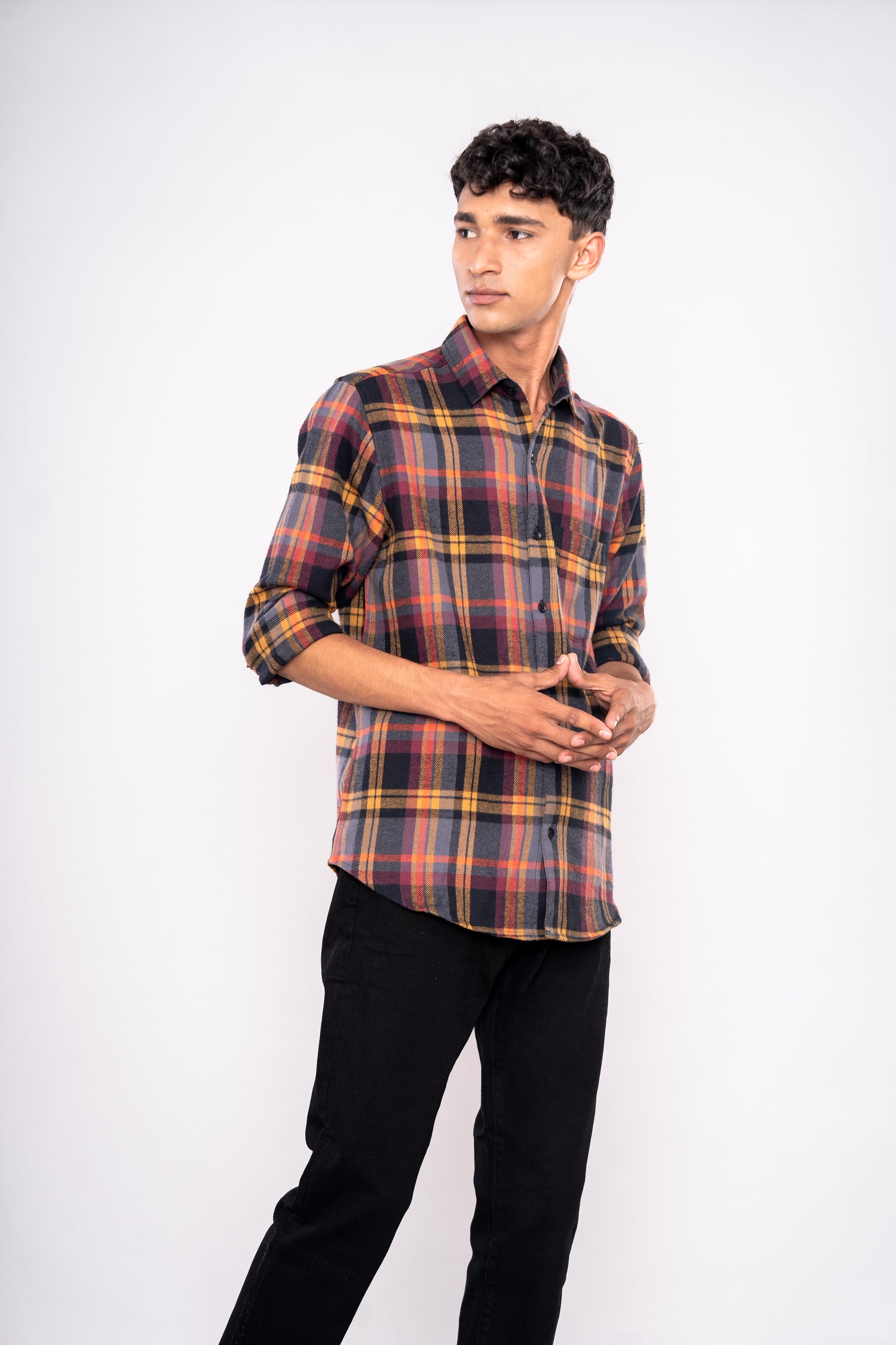Man wearing a plaid shirt and black pants on a white background