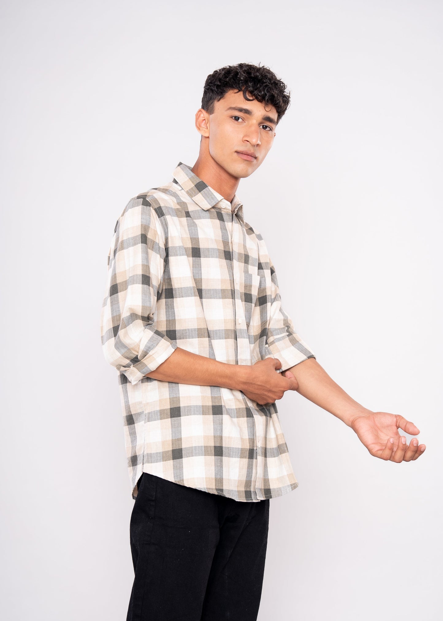 Person wearing a plaid shirt and black pants on a white background