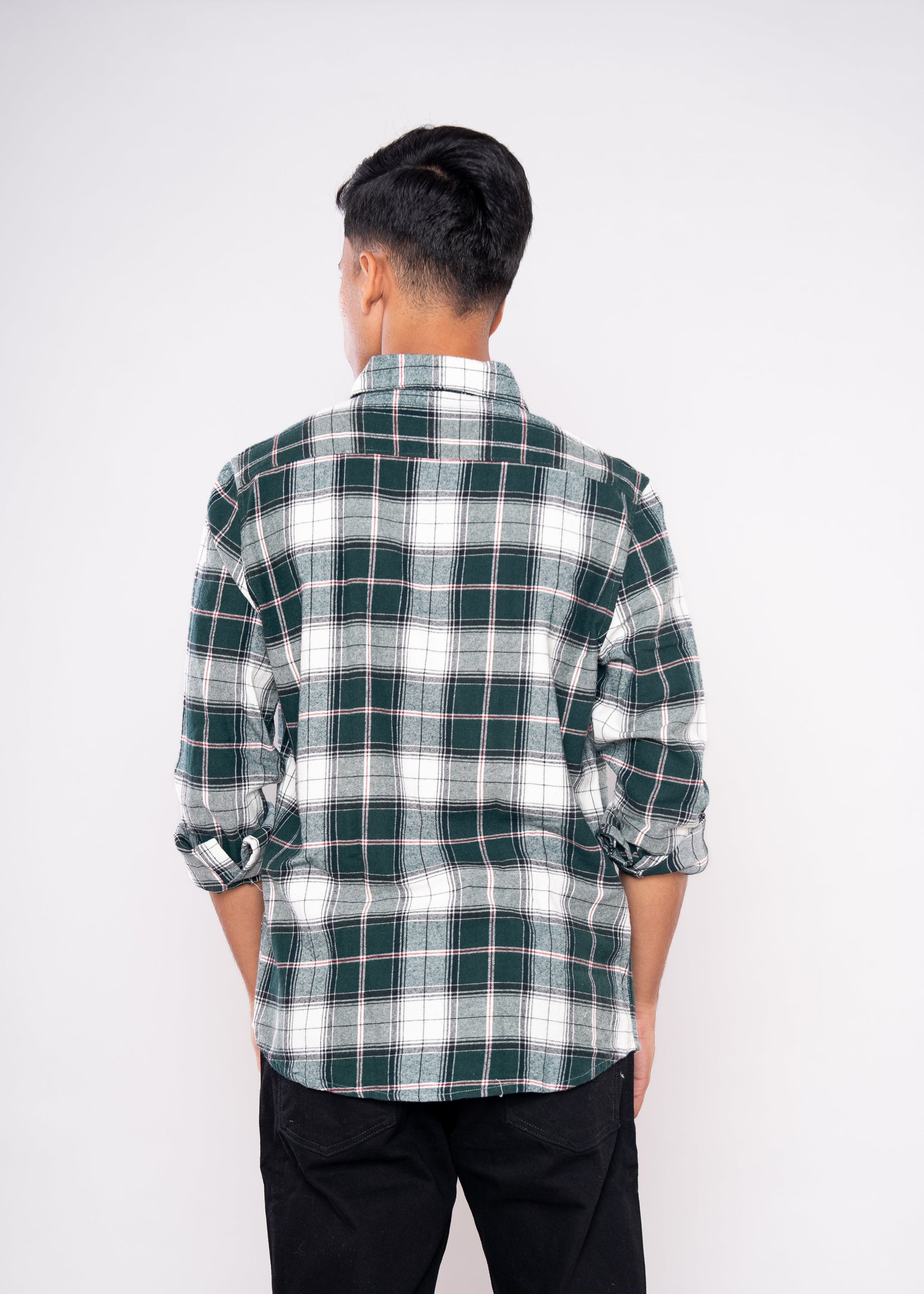 Person wearing a green and white plaid shirt on a white background