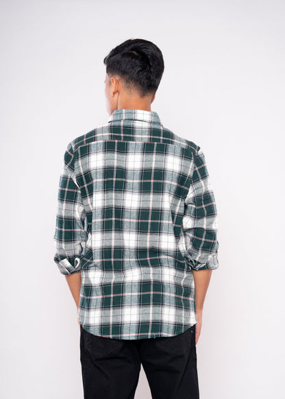 Person wearing a green and white plaid shirt on a white background