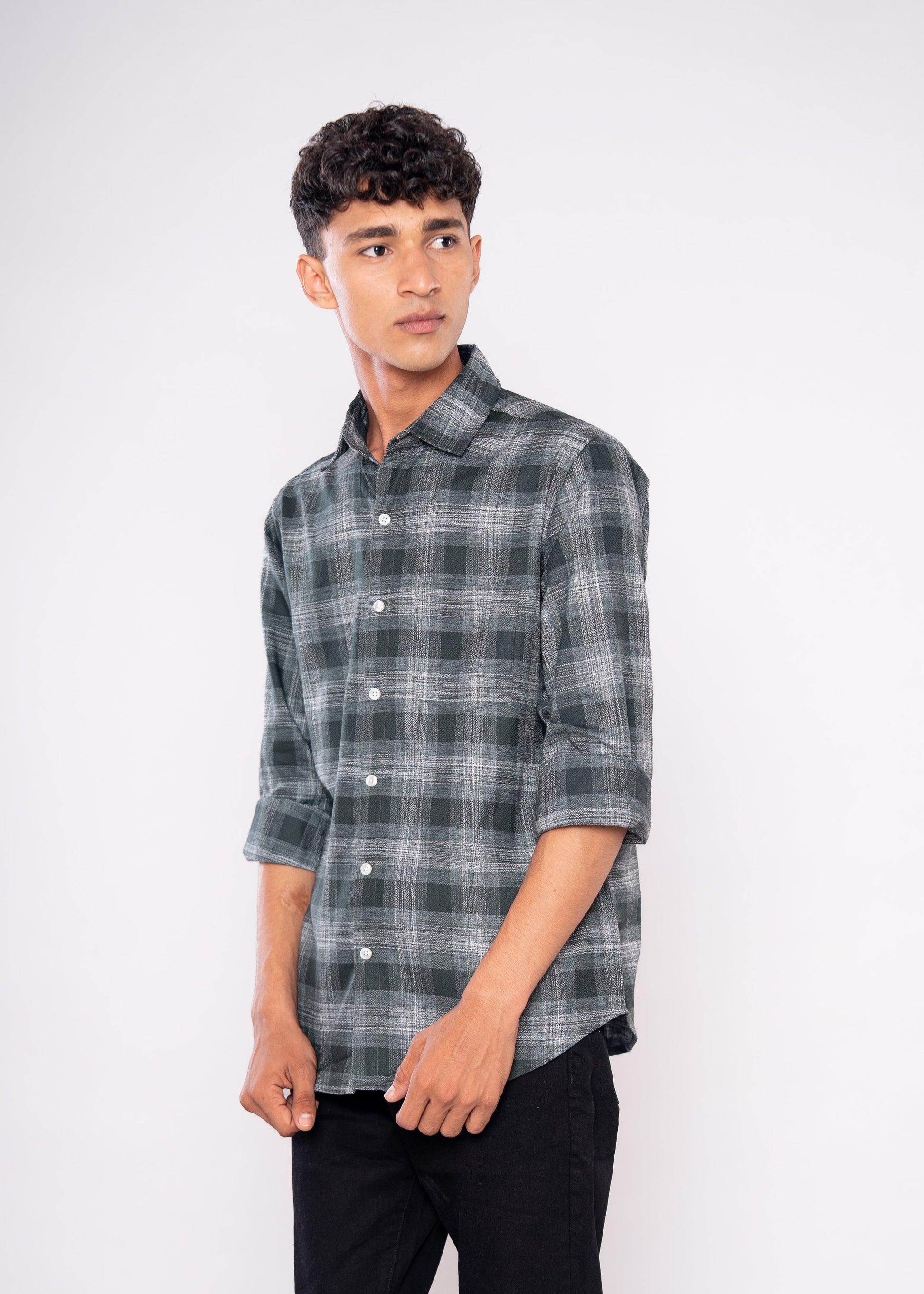 Man wearing a plaid shirt and black pants on a white background