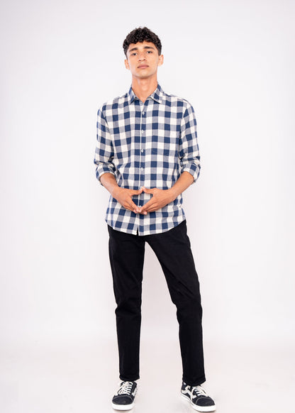 Person wearing a blue and white checkered shirt with black pants on a white background